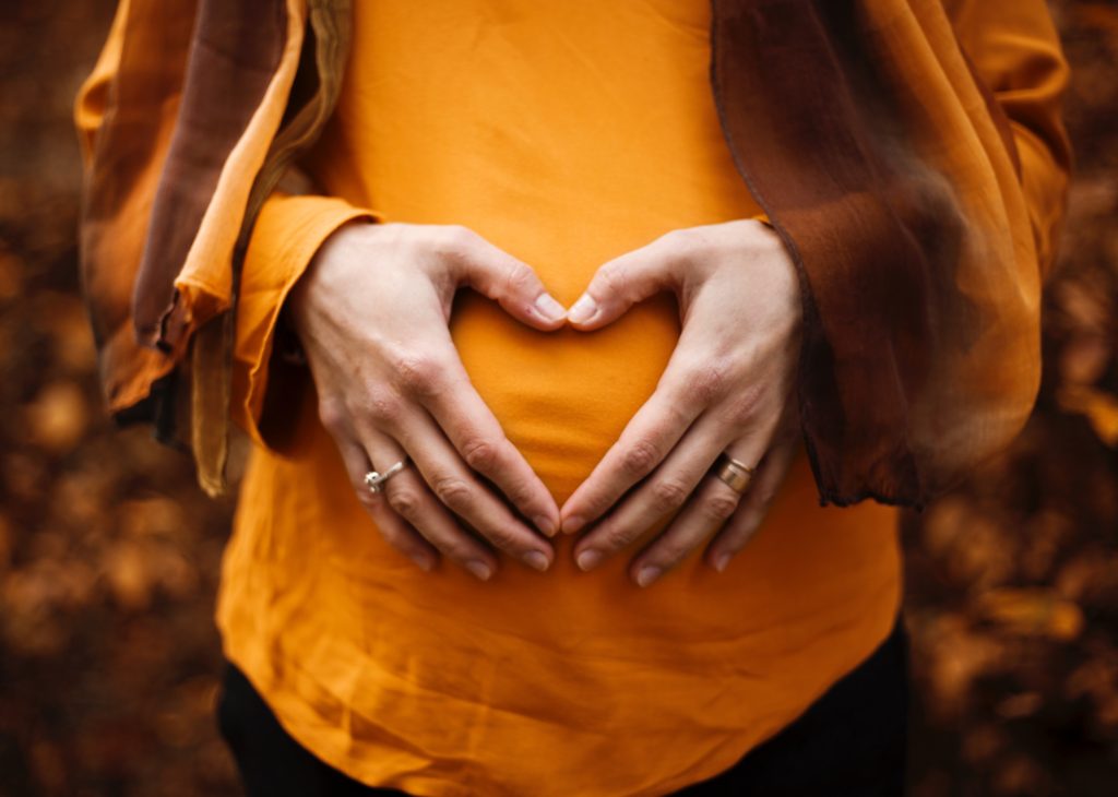 Pregnant woman holding hand over belly