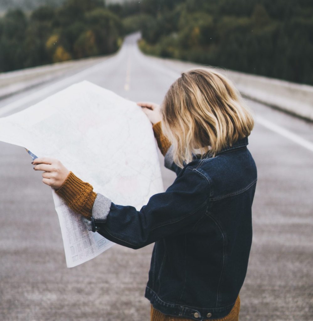 Woman feeling lost in her 30s looking at a map