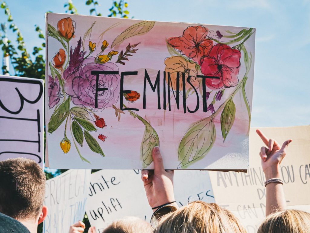women holding feminist sign during protest