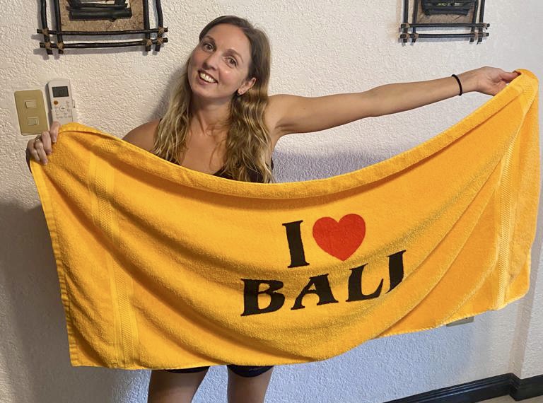 A digital nomad holding a towel that says I love Bali
