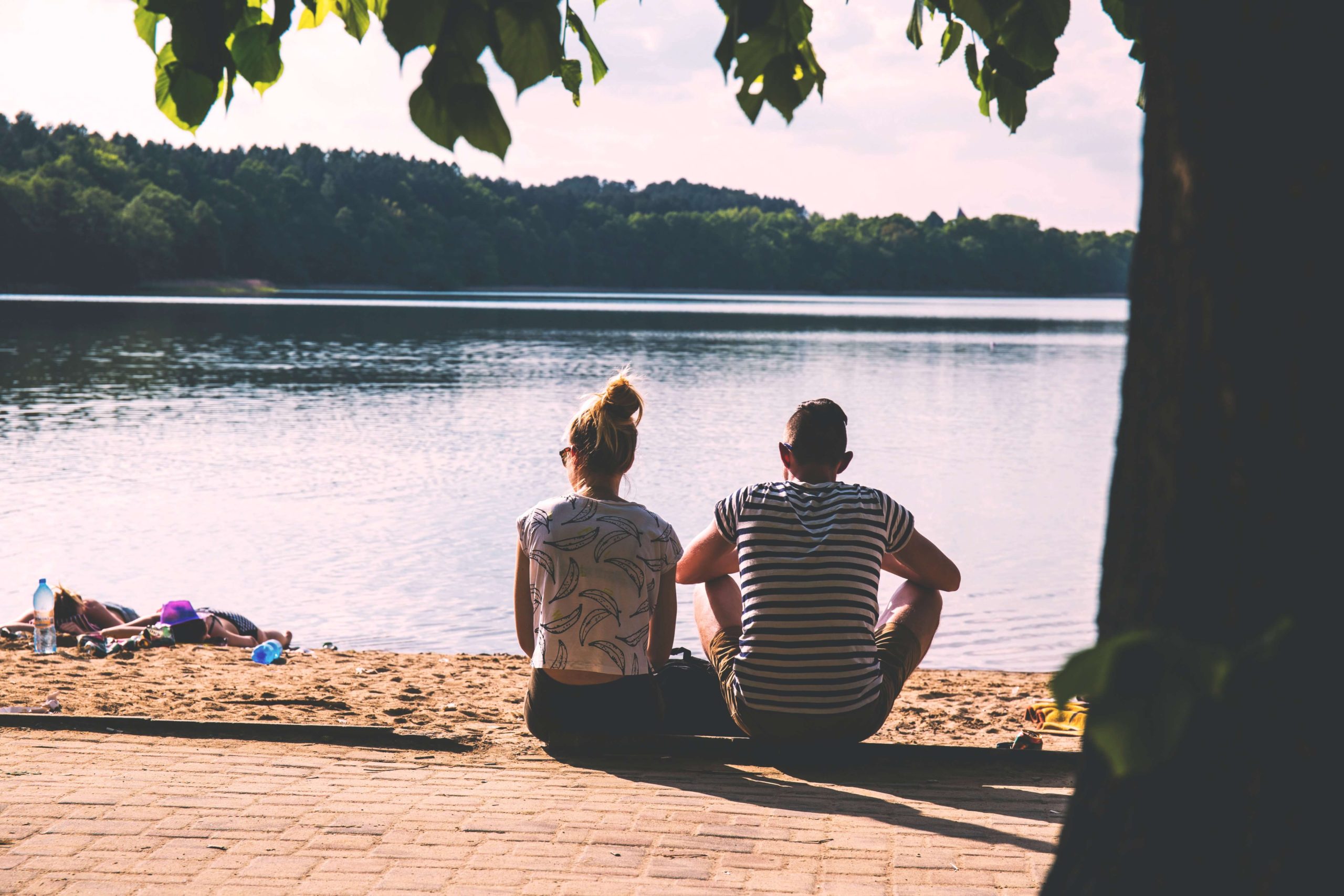 Couple sitting together by the lake