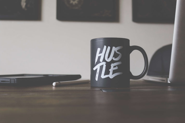Black mug with the word Hustle printed on it